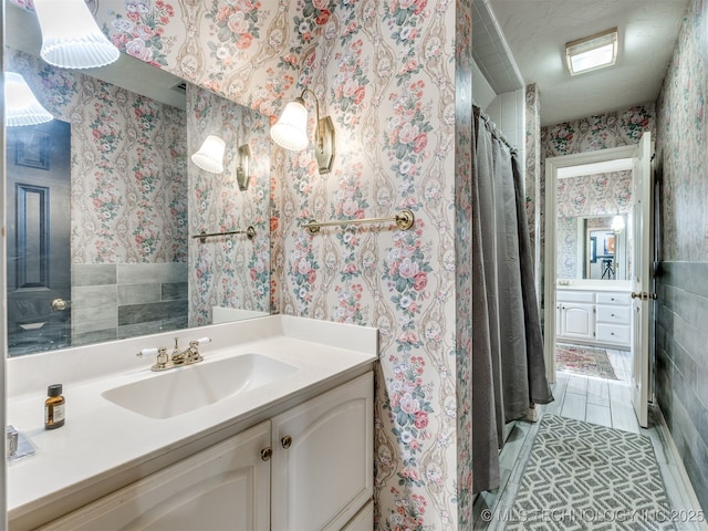 8918 S Lakewood Ave, Tulsa, OK 74137 - full bathroom featuring wallpapered walls, vanity, a shower with curtain, and tile walls