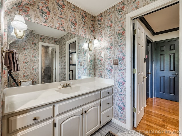 8918 S Lakewood Ave, Tulsa, OK 74137 - bathroom featuring vanity, wood finished floors, crown molding, and wallpapered walls