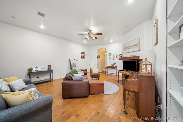 living room with ceiling fan and light wood-type flooring