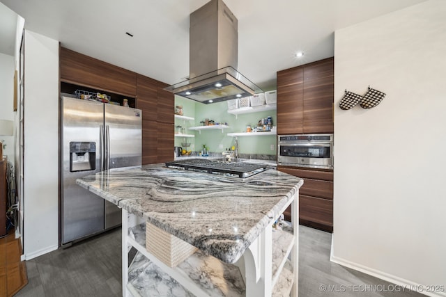 kitchen with a breakfast bar, light stone countertops, appliances with stainless steel finishes, and island exhaust hood