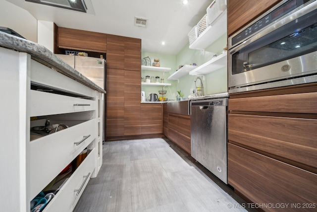 kitchen featuring light hardwood / wood-style flooring, stainless steel appliances, and white cabinets