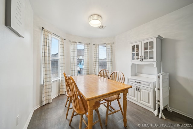 dining room with dark wood-type flooring and a wealth of natural light