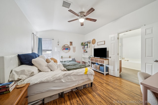 bedroom featuring connected bathroom, light hardwood / wood-style flooring, ceiling fan, and vaulted ceiling