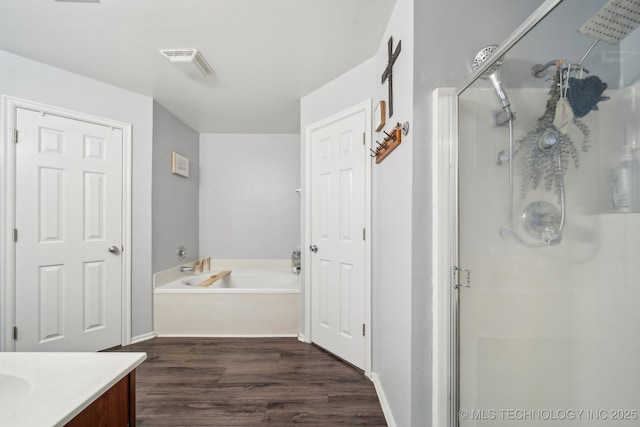 bathroom featuring shower with separate bathtub, hardwood / wood-style floors, and vanity