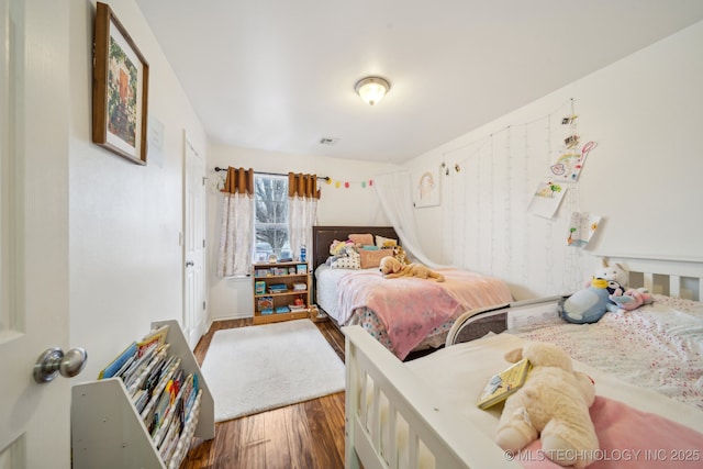 bedroom with dark wood-type flooring