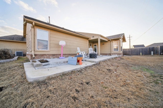 back of property with a patio, central air condition unit, and an outdoor fire pit