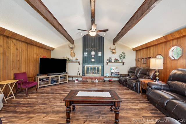 living room featuring a fireplace, wood walls, vaulted ceiling with beams, dark hardwood / wood-style flooring, and ceiling fan