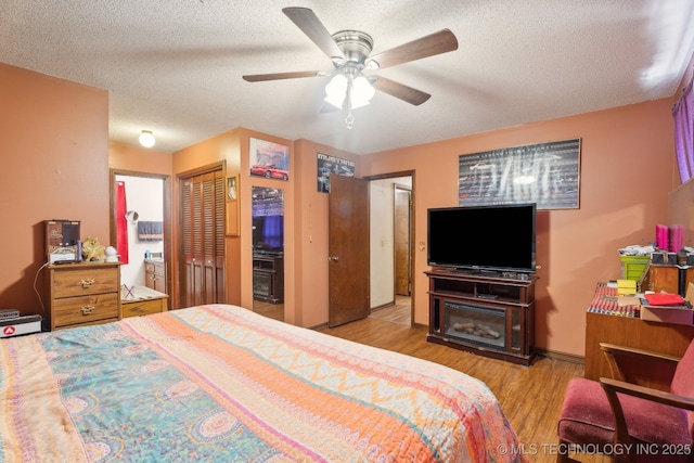 bedroom featuring ceiling fan, light hardwood / wood-style flooring, and a textured ceiling