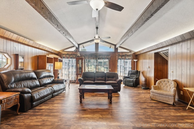 living room featuring ceiling fan, lofted ceiling with beams, a textured ceiling, dark hardwood / wood-style flooring, and wood walls