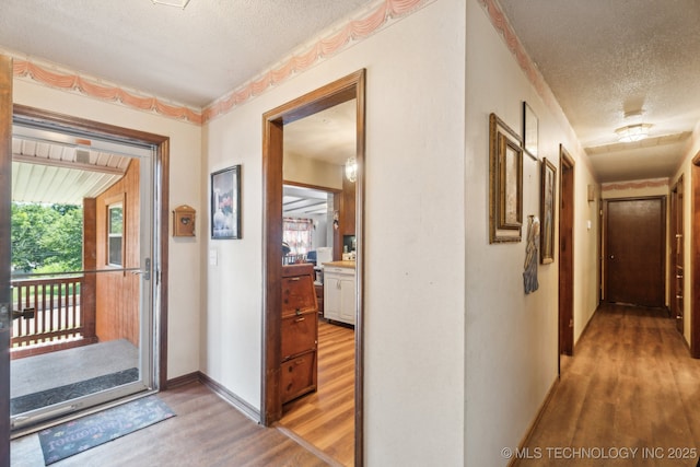 corridor featuring hardwood / wood-style floors and a textured ceiling