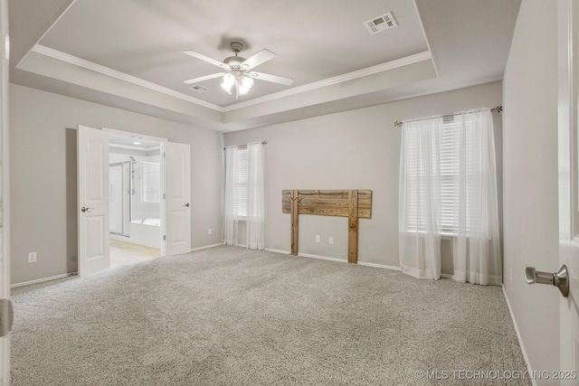 carpeted empty room with ornamental molding, ceiling fan, and a tray ceiling