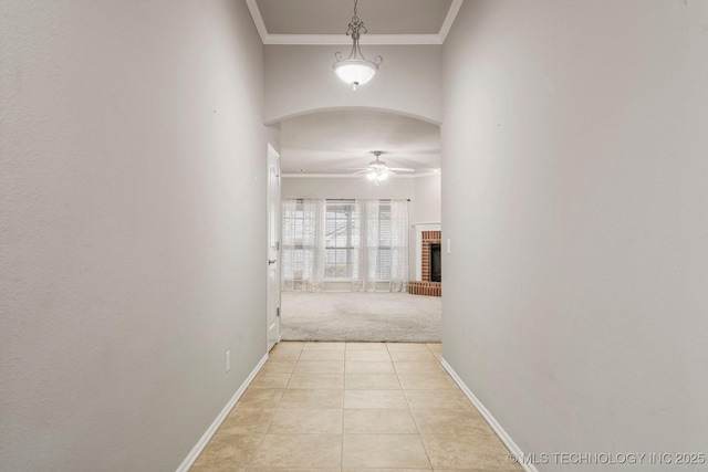 corridor with light tile patterned floors and ornamental molding