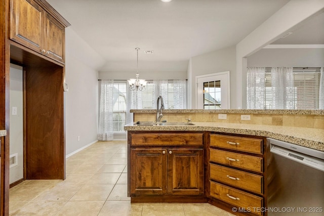 kitchen featuring decorative light fixtures, dishwasher, sink, a chandelier, and light tile patterned floors