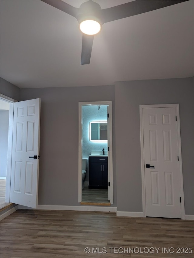 interior space featuring ceiling fan, sink, connected bathroom, and hardwood / wood-style floors