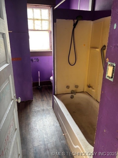 bathroom featuring hardwood / wood-style flooring, toilet, and tub / shower combination