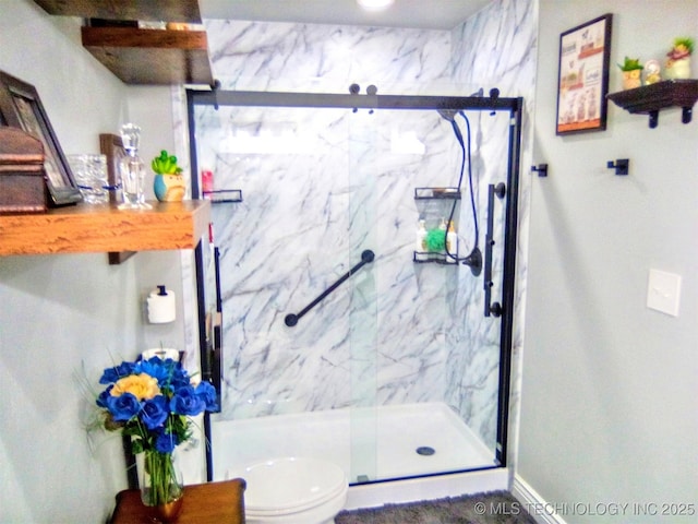 bathroom with toilet and a shower with shower door