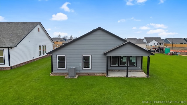 back of house featuring a lawn, a patio, and central air condition unit