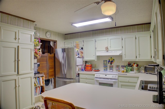 kitchen featuring sink, a textured ceiling, electric range, and stainless steel refrigerator