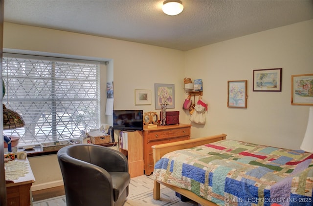 bedroom featuring a textured ceiling and light wood-type flooring