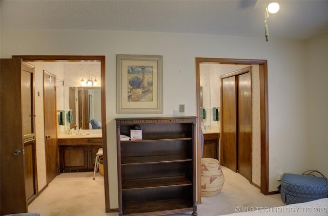 interior space featuring sink, a textured ceiling, and ensuite bath