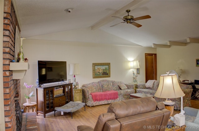 living room with hardwood / wood-style floors, a fireplace, lofted ceiling with beams, and ceiling fan