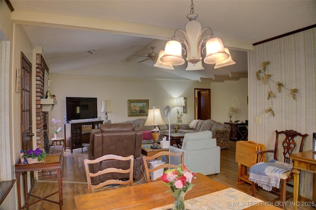 dining room with hardwood / wood-style flooring, ceiling fan with notable chandelier, and lofted ceiling with beams