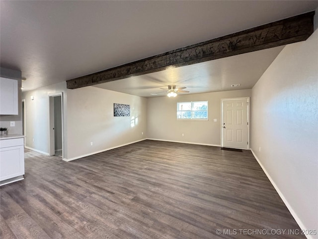 unfurnished living room featuring ceiling fan, dark hardwood / wood-style floors, and beamed ceiling