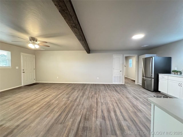 unfurnished living room with beam ceiling, light hardwood / wood-style flooring, and ceiling fan