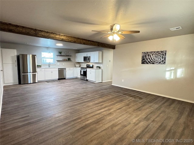 unfurnished living room with beamed ceiling, ceiling fan, and dark hardwood / wood-style flooring