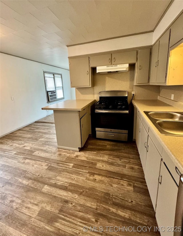 kitchen featuring sink, gas range, dark hardwood / wood-style floors, and kitchen peninsula