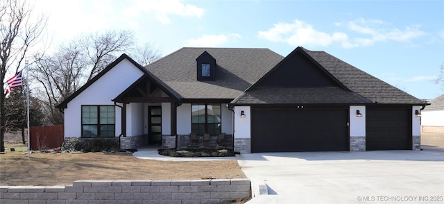 view of front facade featuring stone siding, an attached garage, concrete driveway, and a shingled roof