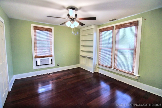 empty room with cooling unit, dark hardwood / wood-style flooring, and ceiling fan