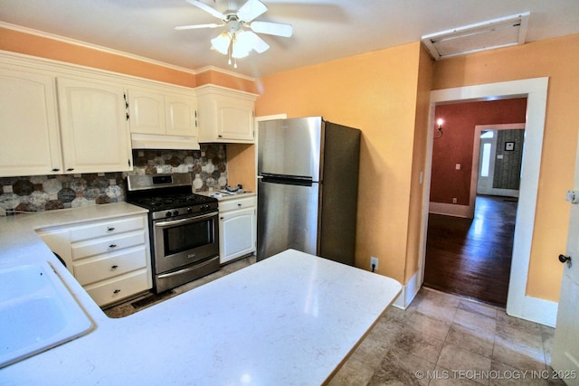 kitchen featuring sink, ceiling fan, white cabinetry, stainless steel appliances, and decorative backsplash