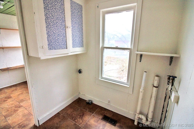 clothes washing area with cabinets