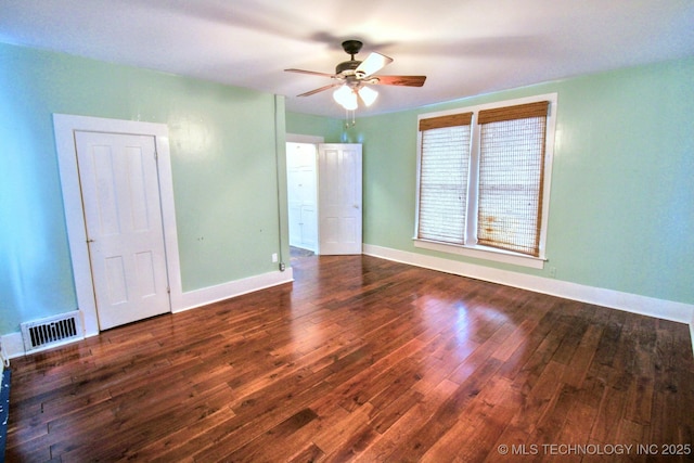 spare room with dark wood-type flooring and ceiling fan