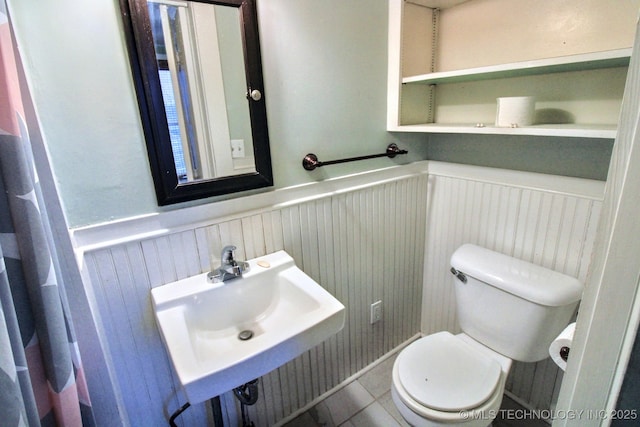 bathroom with tile patterned flooring, sink, and toilet