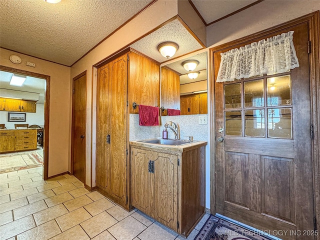 kitchen featuring light tile patterned flooring, sink, and a textured ceiling