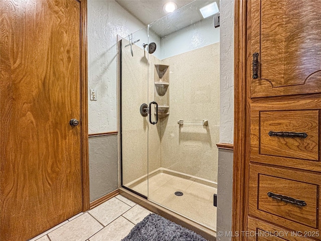 bathroom with tile patterned flooring and a shower with shower door