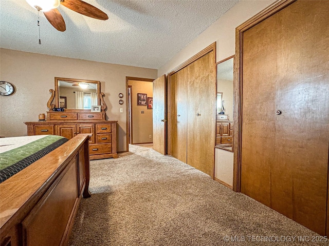 carpeted bedroom featuring ceiling fan and a textured ceiling