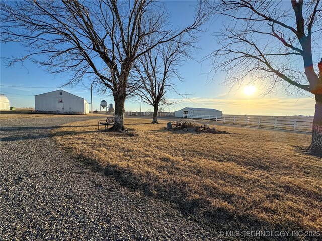 yard at dusk featuring an outbuilding