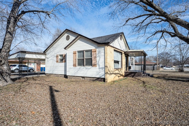 view of side of property with a carport and covered porch