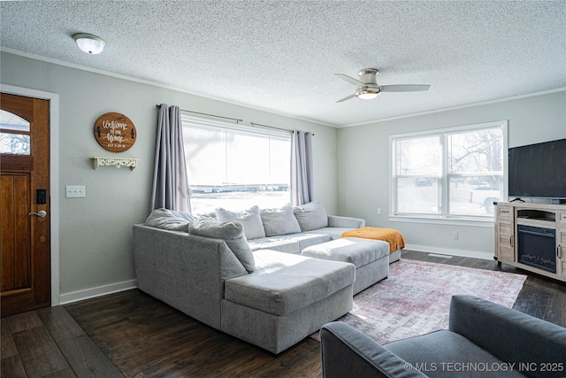 living room featuring a healthy amount of sunlight, dark wood-type flooring, a textured ceiling, and crown molding