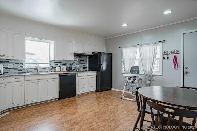 kitchen featuring sink, white cabinetry, black appliances, light hardwood / wood-style flooring, and backsplash