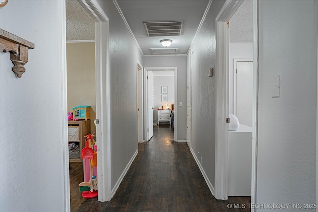 corridor featuring dark hardwood / wood-style flooring, crown molding, and a textured ceiling