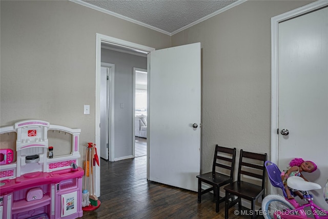 recreation room with crown molding, dark hardwood / wood-style floors, and a textured ceiling