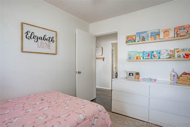 bedroom featuring ornamental molding and a textured ceiling