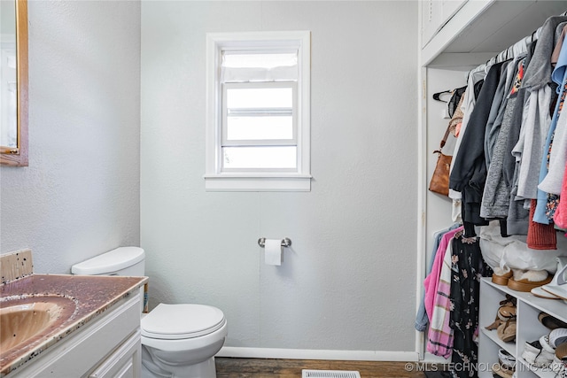 bathroom featuring vanity, hardwood / wood-style floors, and toilet