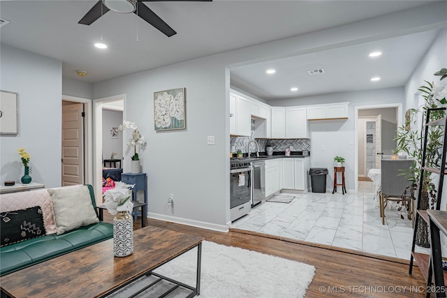 living room with sink, light hardwood / wood-style flooring, and ceiling fan