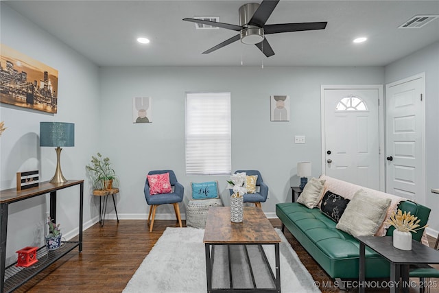 living room featuring dark wood-type flooring and ceiling fan