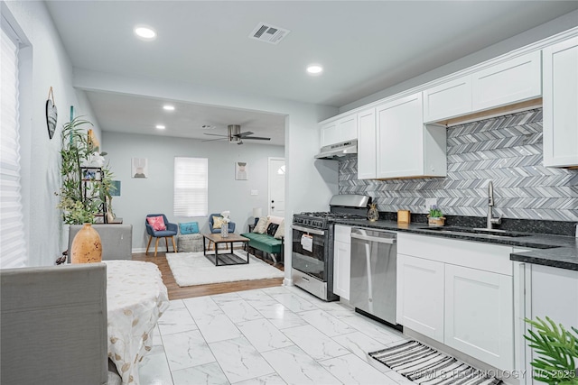 kitchen featuring stainless steel appliances, sink, decorative backsplash, and white cabinets